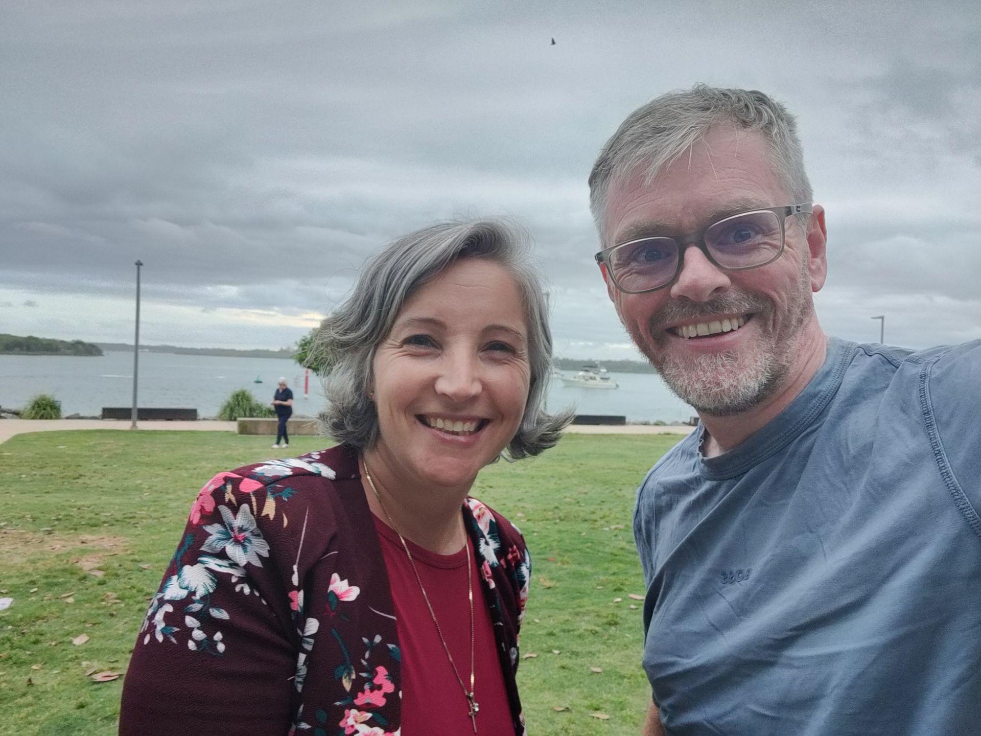 two people taking a photo by the river